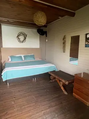 a bedroom with a bed and a wooden floor at El Arca in Tintipan Island