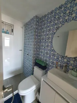 a bathroom with a toilet and a sink and a mirror at Acogedor Apto en piso 22 vista al mar in Cartagena de Indias