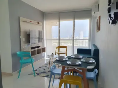 a living room with a table and chairs at Acogedor Apto en piso 22 vista al mar in Cartagena de Indias