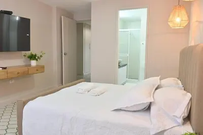 a bedroom with a bed with white sheets and pillows at Apartahotel Edificio Baquero x10 Apto 403 in Barranquilla