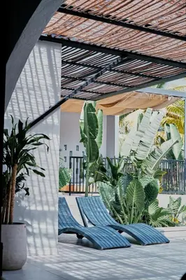a patio with two lounge chairs and plants at Gaia Casa de Mar in El Bobo