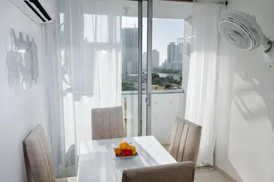 a white table with a bowl of fruit on it in front of a window at Acogedor apartamento en Cartagena/asequible in Cartagena de Indias