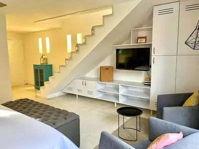 a living room with a tv and a staircase at by Calamari Homes - Parque Centenario casa 206 walled city in Cartagena de Indias