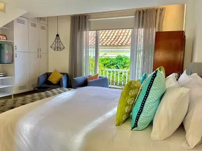 a bedroom with a large white bed with pillows at by Calamari Homes - Parque Centenario casa 206 walled city in Cartagena de Indias