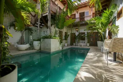 a swimming pool in a courtyard with plants at Palmas de Alba Hotel Boutique in Cartagena de Indias