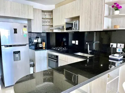 a kitchen with a stainless steel refrigerator and a sink at by Calamari Homes - Infinitum 3302 Bocagrande in Cartagena de Indias