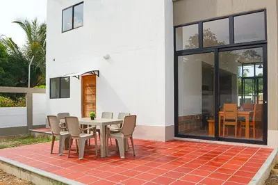 a patio with a table and chairs on a brick floor at CABAÑA PLAYA MAR in Coveñas