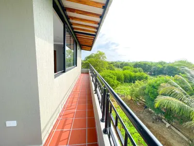 a balcony with a view of a garden at CABAÑA PLAYA MAR in Coveñas