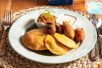 a plate of food with potatoes and other foods on a table at ACASI Rustic Beach in Baru