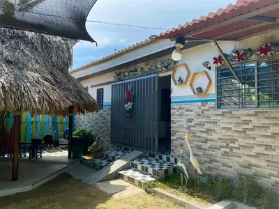 a house with a black door and a patio at Cabaña en Santiago de Tolú. in San Silvestre