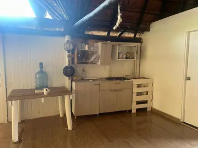 a kitchen with a table and a stove in a room at Punta Arena EcoHostal & EcoFit in Playa Punta Arena