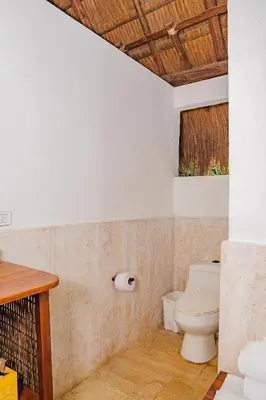 a bathroom with a toilet and a wooden ceiling at U-GO Espectacular Casa en Barú con Vistas al Mar in Cartagena de Indias