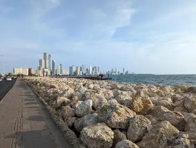 a rock wall next to the ocean with a city at U-GO Edificio Murano Elite Bocagrande Frente al Mar in Cartagena de Indias