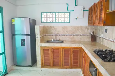 a kitchen with a sink and a refrigerator at Cabaña Tierramia 1 in San Silvestre