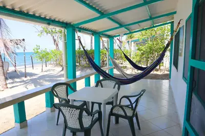 a porch with a table and chairs and a hammock at Cabaña Tierramia 1 in San Silvestre