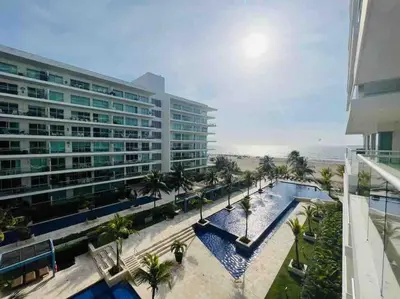 a large building with a swimming pool next to a beach at Cartagena in Cartagena de Indias