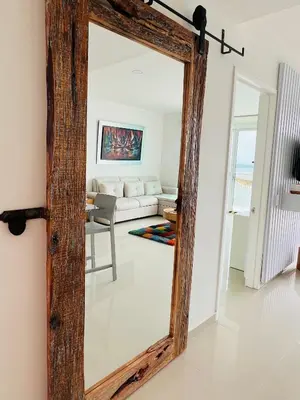 a mirror with a wooden frame in a living room at Cartagena in Cartagena de Indias
