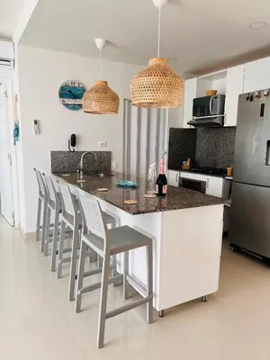 a kitchen with a counter with stools and a refrigerator at Cartagena in Cartagena de Indias