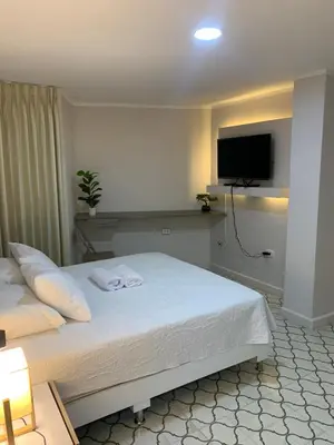 a bedroom with a bed with a tv on the wall at Apartahotel Edificio Baquero x5 Apto 401 in Barranquilla