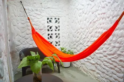 an orange hammock in a room with a table at Apartamento Arenita de mar in Coveñas