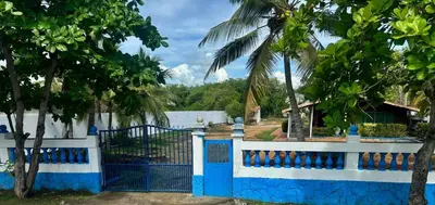 a blue and white fence with a palm tree at SiÉ Cabaña en Coveñas cerca a la playa in Coveñas