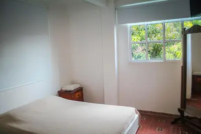 a bedroom with a bed and a window at Hotel - Granja de Animales San Basilio de Palenque in San Basilio del Palenque