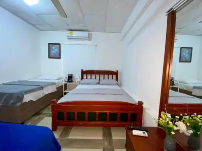 a bedroom with two beds and a mirror at Habitación Multiple cerca de aeropuerto in Cartagena de Indias