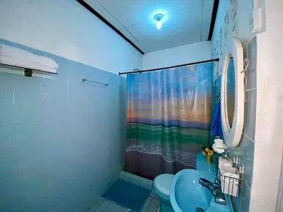a bathroom with a rainbow shower curtain and a toilet at Habitación Multiple cerca de aeropuerto in Cartagena de Indias