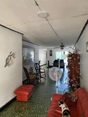a living room with a cat laying on a red couch at Habitación Multiple cerca de aeropuerto in Cartagena de Indias