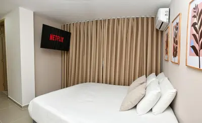 a hotel room with a bed with white pillows at Excelente ubicación y cómodo apto, perfecto para ti! in Barranquilla