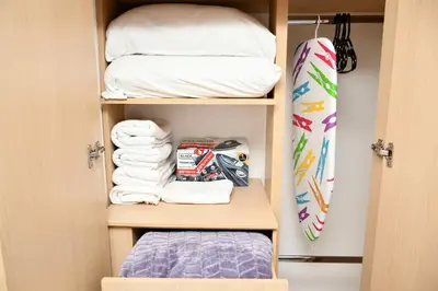 a closet with towels and a surfboard at Excelente ubicación y cómodo apto, perfecto para ti! in Barranquilla