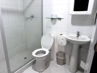 a white bathroom with a toilet and a sink at Hotel bazurto plaza in Cartagena de Indias