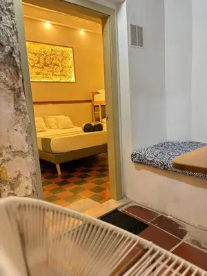 a room with a bedroom with a bed and a mirror at Casa Zaguan in Cartagena de Indias