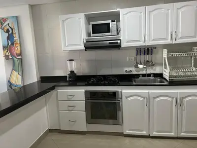 a kitchen with white cabinets and a microwave at Torres del lago de 3 habitaciones in Cartagena de Indias
