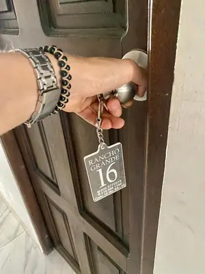a person unlocking a door with a key at Hotel Rancho Grande in Barranquilla