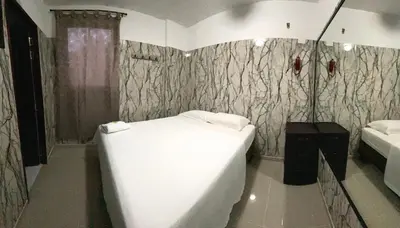 a bedroom with a large white bed in a room at Hotel Rancho Grande in Barranquilla