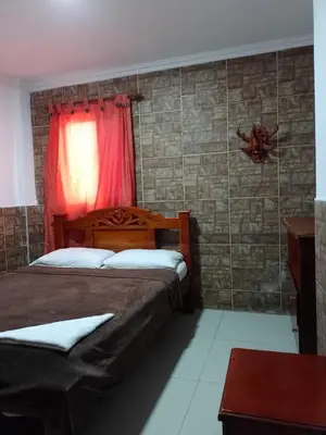 a bedroom with two beds and a red curtain at Hotel Palma Real Cartagena in Cartagena de Indias
