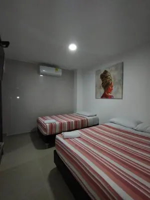 a room with two beds and a painting on the wall at HOTEL BELLAMAR in Cartagena de Indias