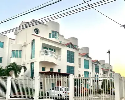 a white building with a white car in front of it at Casa de Lujo en Condominio Privado por habitaciones in Cartagena de Indias