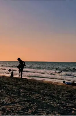 a man standing on the beach at sunset at Sharick Beach House in Tubará