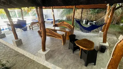 a room with a hammock and a table and chairs at Sharick Beach House in Tubará