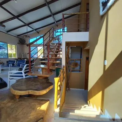 a living room with a staircase and a table and bench at Espectacular Cabaña en Santa Veronica in Santa Veronica