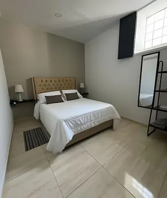a white bedroom with a bed and a window at Céntrico y confortable apto casa Doña yola 5 in Cartagena de Indias
