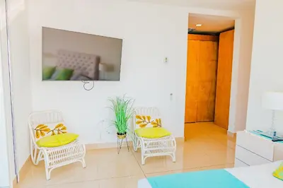 a room with two chairs and a table with yellow pillows at U-GO Edificio H2 en Bocagrande Frente al Mar in Cartagena de Indias
