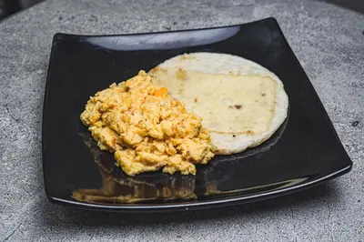 a plate of food with an egg and a bread at Hotel & Restaurante Oasis CTG in Cartagena de Indias