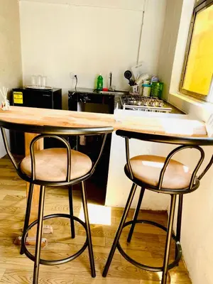 a kitchen with two bar stools and a counter at Aparta Hotel Manzur in Barranquilla