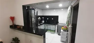 a kitchen with a black counter and a refrigerator at Habitacion Medusa in Barranquilla