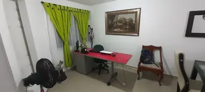 a room with a red desk and a green curtain at Habitacion Medusa in Barranquilla