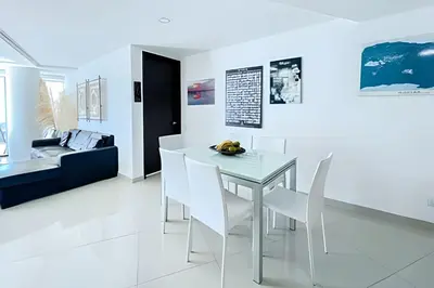 a white dining room with a white table and chairs at Apartamento 2 Dormitorios Morros. Vista Mar in Cartagena de Indias