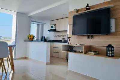 a kitchen with a large flat screen tv on a wall at Apartamento de descanso Om Shanti Om in Coveñas